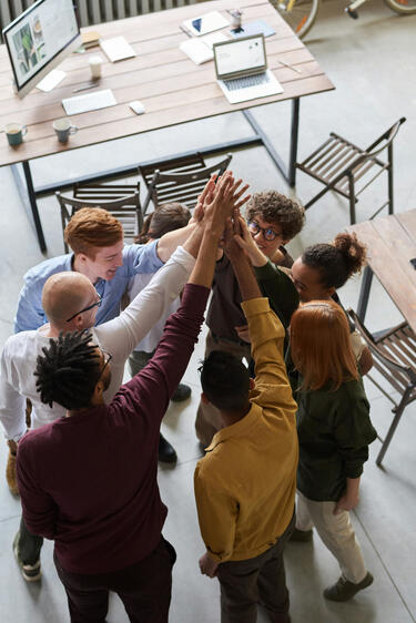 Team members high fiving each other as a sign of celebration | EvoKomms