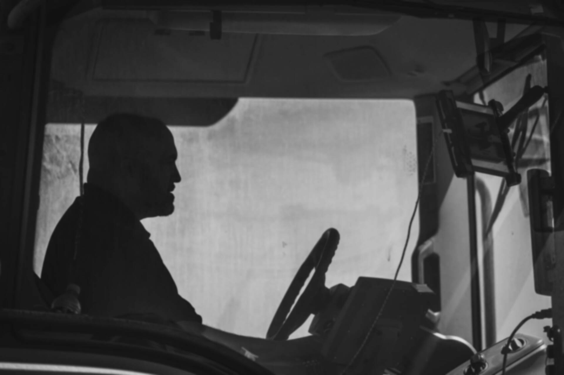 Truck driver checking EvoKomms app on a tablet in his cabin at night | EvoKomms